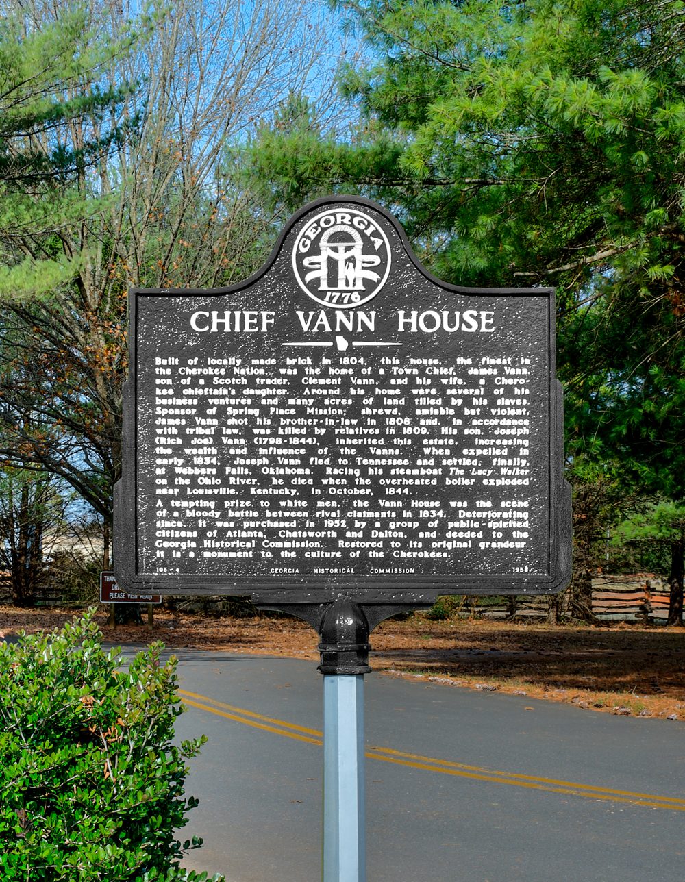 Black cast-metal Georgia historical marker headed “Chief Vann House,” standing beside a paved road among trees.